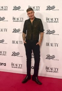 TJ Shirley of TJtutorials standing with his hands in his pockets on the red carpet in front of The Beauty Awards 2025 and Boots backdrop.
